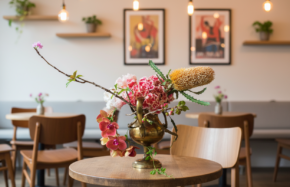 Banksia, orchids, and hydrangeas in brass compote